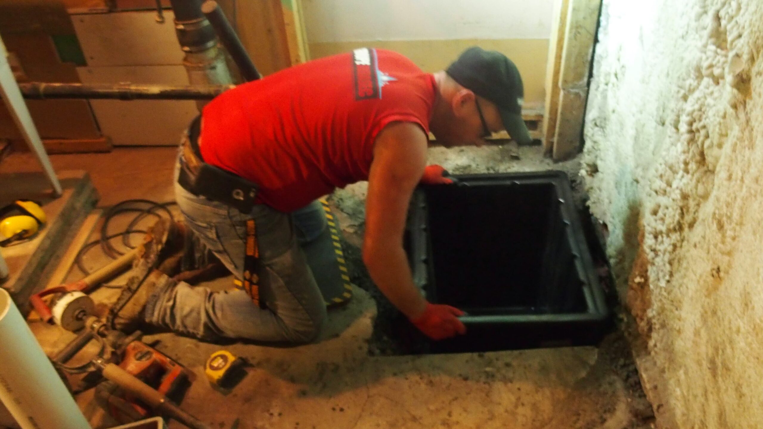 Un professionnel installe un bassin de captation en plastique dans un plancher de béton